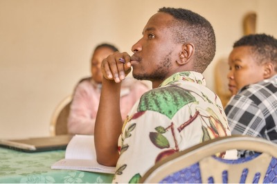 A man sitting by a table holding a pencil