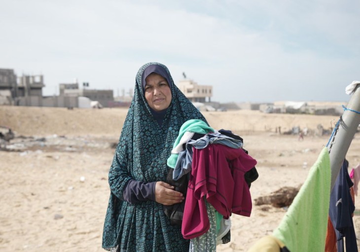 Muna ordner vasketøj ved sit telt i Al Mawasi (Palæstina)