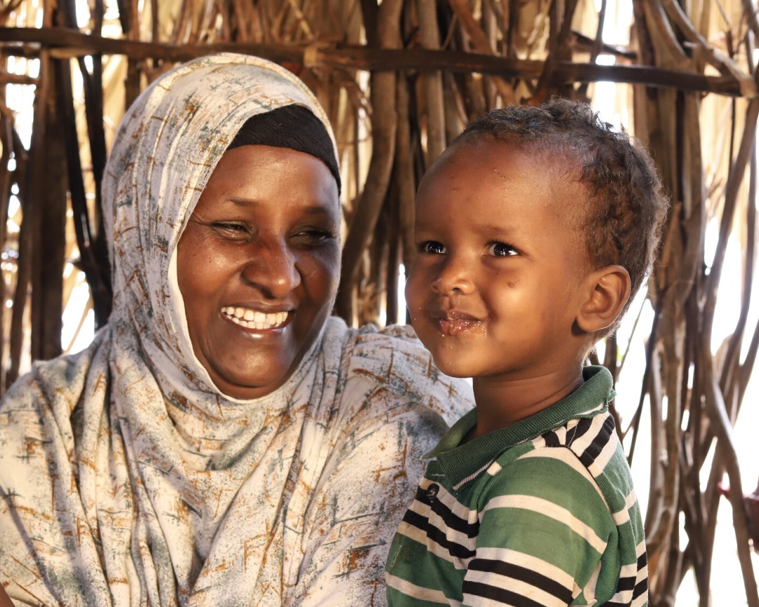 Abdia Ibrahim, program participant of the water project in Barambale in Isiolo county where a water point was set up by MID -P in partnership with Oxfam drinks tea with her son.