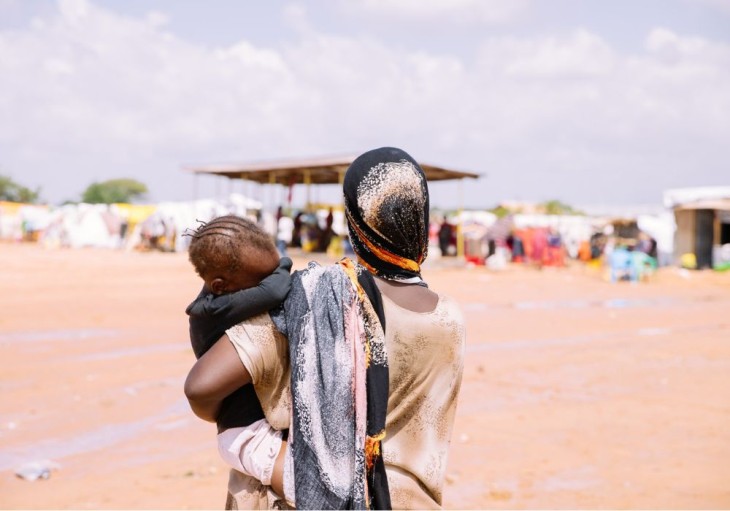 Fatuma Salat Shoro bærer sit barn i Ziwani-lejren for internt fordrevne. Hun blev for nylig fordrevet af de ubarmhjertige oversvømmelser efter kraftige regnskyl i området. El Nino-fænomenet fortsætter med at forårsage voldsomme regnskyl i området, hvilket skader ejendom og forstyrrer livet i lokalsamfundene.