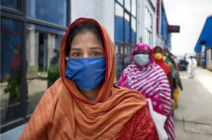 Tørklædeklædt kvinde med mundbind under COVID-19 pandemien