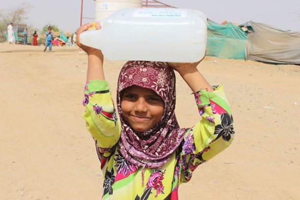 Lille pige bærer vanddunk på hovedet, Yemen