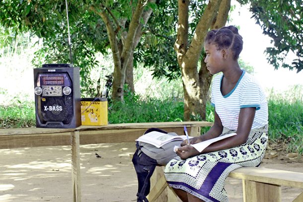Skolepige lytter til skoleradio i Mozambique