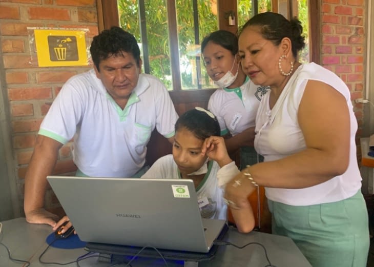 Kvinde, børn og mand ved laptop