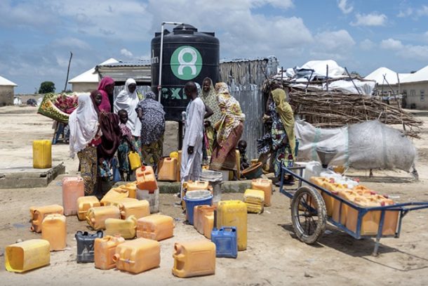 Oxfam uddeler vand i flygtningelejren Farm State i Nigeria.