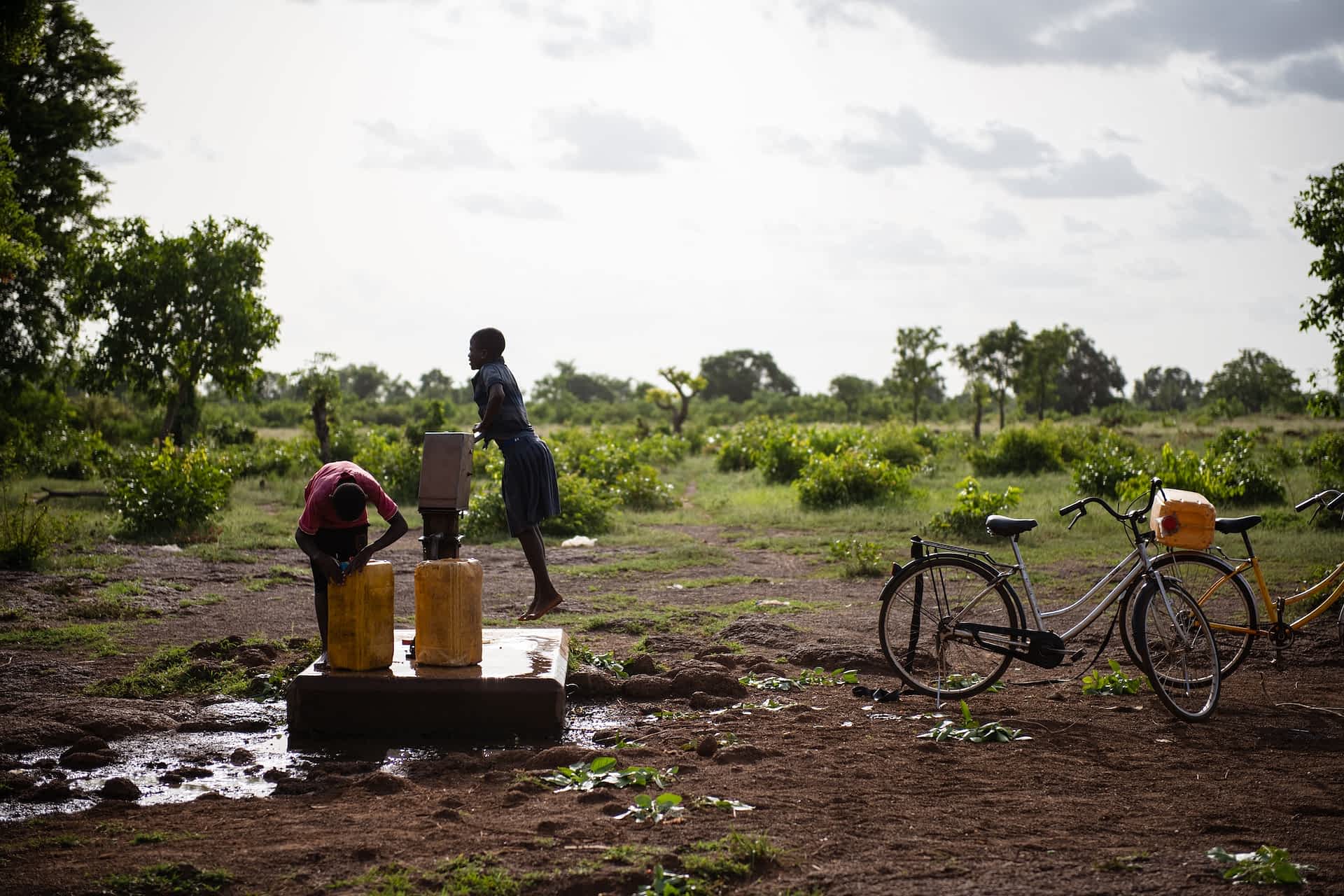 To mennesker der henter vand i dunke fra en brønd